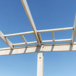 Vue en contre-plongée d’une charpente préfabriquée en béton installée sur un bâtiment en cours de construction