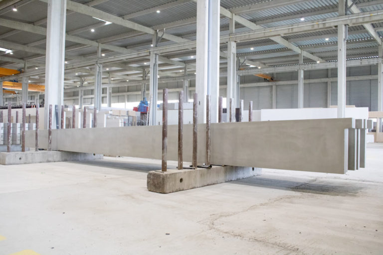 Linteaux en béton brut de grande longueur, entreposés dans l'usine CIR PREFA