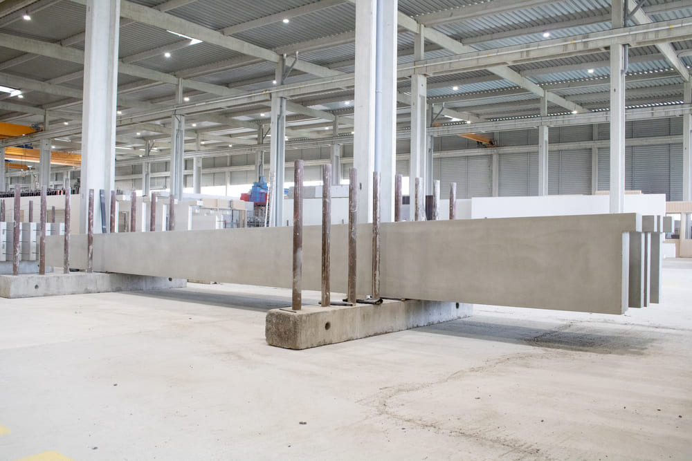Linteaux en béton brut de grande longueur, entreposés dans l'usine CIR PREFA
