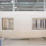 Mur plein avec texture striée et ouverture rectangulaire en béton préfabriqué