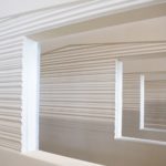 Zoom sur une ouverture encadrée dans un mur plein à texture striée