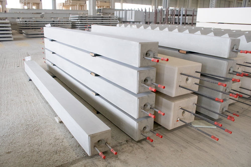 Vue latéral des poteaux en béton préfabriqué empilés dans l’usine CIR PREFA