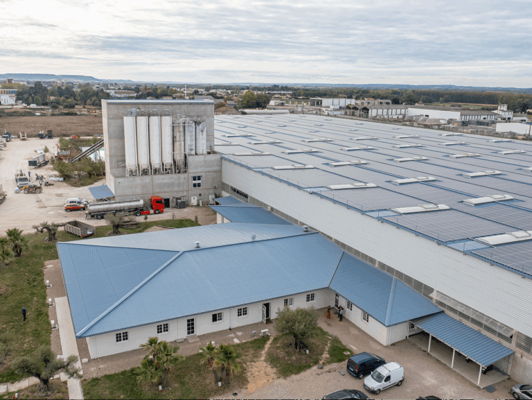 Vue aérienne du site industriel de CIR PREFA à Fauillet, présentant les silos à béton, les zones de stockage et les bâtiments de production couverts de panneaux photovoltaïques