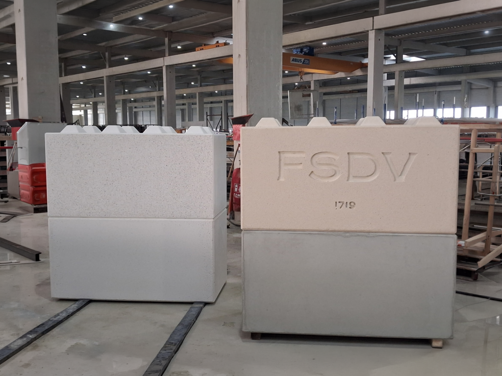 Blocs béton préfabriqués empilables CIR PREFA présentés en usine, dont un modèle personnalisé avec marquage FSDV en relief.